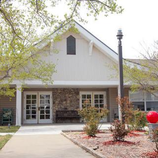 A small house with a front entrance and surrounding landscaping.