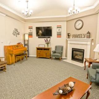 A cozy living room featuring a piano, fireplace, and comfortable seating.