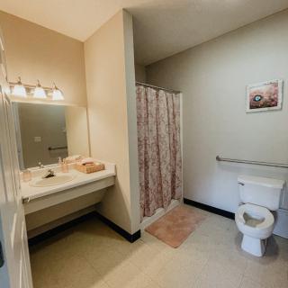 A clean and organized bathroom with a shower, sink, and toilet.