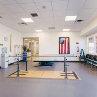 A physical therapy clinic equipped with parallel bars and exercise equipment for rehabilitation.