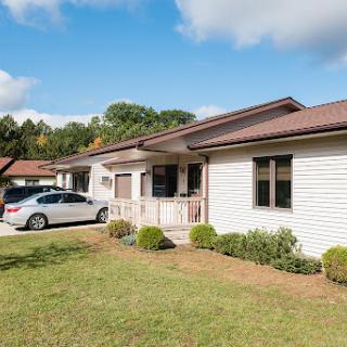 A charming single-story house with a well-maintained front yard and parked car.