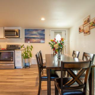 A cozy kitchen and dining area with a wooden table, chairs, and modern appliances.