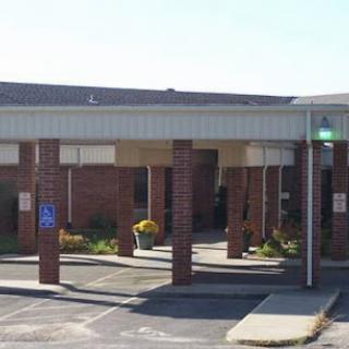 A healthcare facility with a welcoming entrance and parking area.