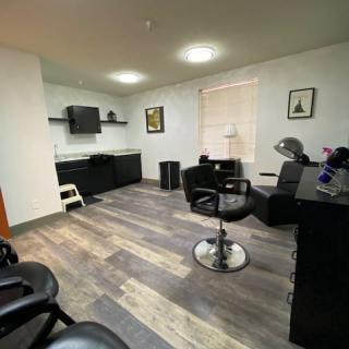A modern hair salon interior with styling chairs and workstations.