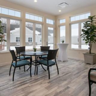 A bright and airy dining area with large windows and plants.