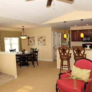 An open-plan living area featuring a cozy dining space, a kitchen with bar stools, and stylish interior design elements.