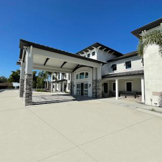 A modern architectural design featuring a spacious entrance and clear blue skies.