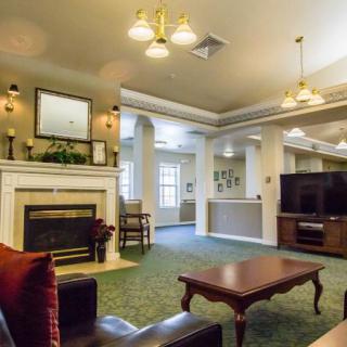 A cozy living room with a fireplace and television, featuring comfortable seating and a coffee table.
