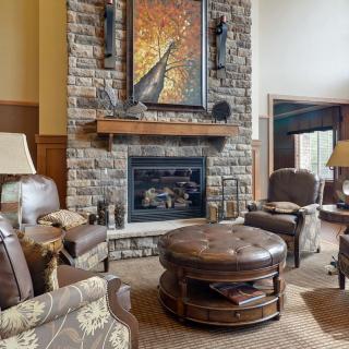 A cozy living room with a stone fireplace and comfortable seating.