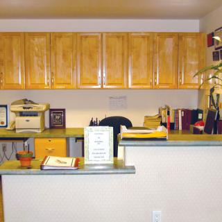 A well-organized reception desk with cabinets and office supplies.