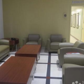 A quiet waiting area with comfortable chairs and wooden tables.