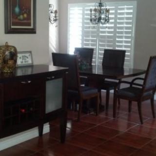 A well-furnished dining room with a dark wooden table and chairs.