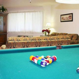 A cozy living room with a pool table and comfortable seating.