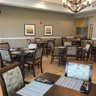 A modern dining area with neatly arranged tables and chairs, featuring tasteful decor.