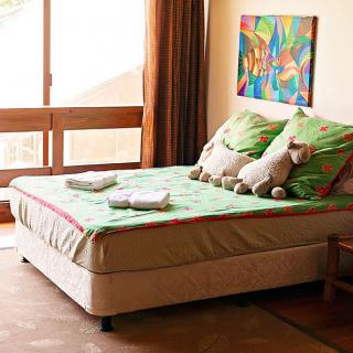 A cozy bedroom with vibrant bedding and playful decor.