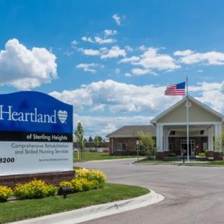 A healthcare facility with an American flag and a sign reading 'Heartland.'