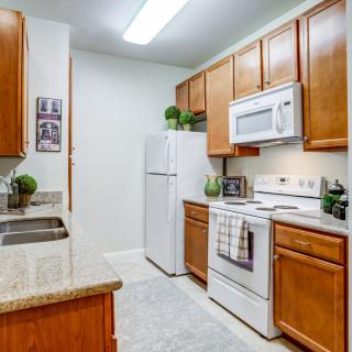 A modern kitchen with wooden cabinets and white appliances.