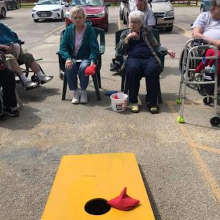 Seniors enjoying a lively game of cornhole in the community.
