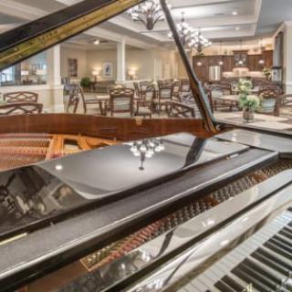A luxurious restaurant interior with a grand piano in the foreground.