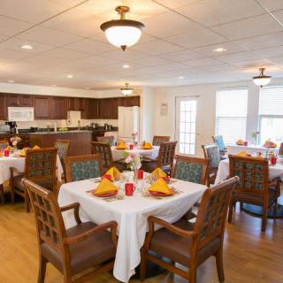 A well-decorated dining room with multiple tables and chairs set for a meal.
