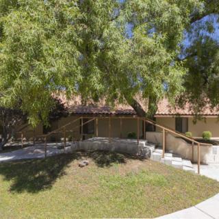 A serene outdoor setting featuring a building surrounded by trees and a winding pathway.