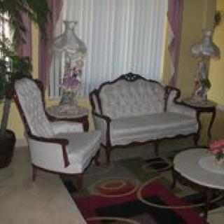 A vintage-style living room with a sofa, armchair, and decorative elements.