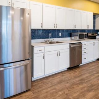A modern kitchen with stainless steel appliances and white cabinetry.