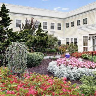 A beautifully landscaped garden with vibrant flowers in front of a white building.