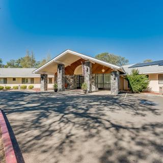 A sunny day view of a building entrance with a wide driveway.
