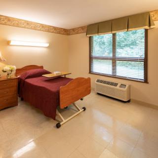 A well-lit hospital room featuring two beds with a simple and functional design.