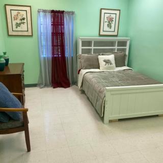 A cozy bedroom with mint green walls and simple decor.
