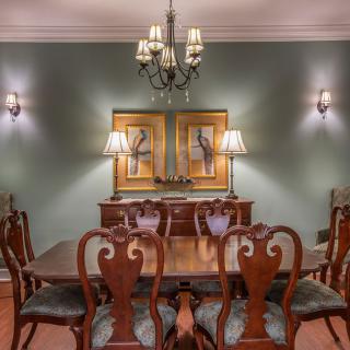 An elegant dining room with classic wooden furniture and a chandelier lighting.