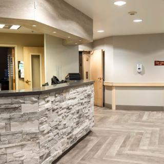 A modern hospital reception area with a stone wall and well-lit surroundings.
