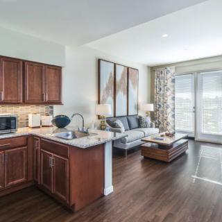 Modern open-concept kitchen and living room with hardwood floors.