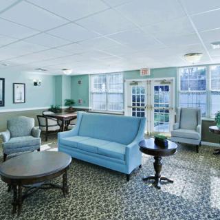A cozy living room with blue sofa and armchairs.