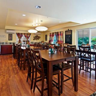 A cozy restaurant dining area with wooden tables and chairs, warmly decorated.