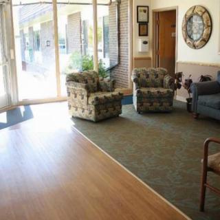 A well-lit waiting room with armchairs and a cozy seating arrangement.