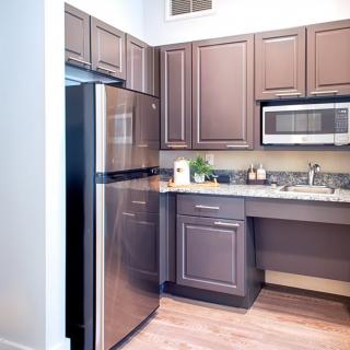 A modern kitchen featuring stainless steel appliances and wooden cabinets.