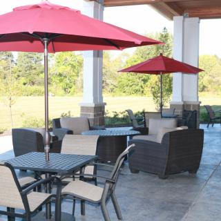 An inviting outdoor patio with red umbrellas and comfortable seating arrangements.