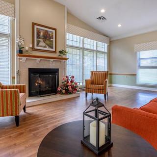 A cozy living room featuring a fireplace, stylish seating, and large windows that allow natural light to fill the space.