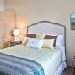 A cozy and well-decorated bedroom with a comfortable bed and bedside lamp.