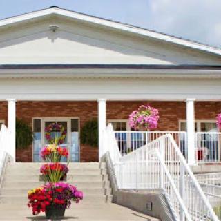 A welcoming entrance with vibrant flowers leading up to a beautifully designed building.