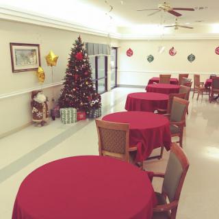 A festive dining area adorned with red tablecloths and a Christmas tree, perfect for holiday celebrations.