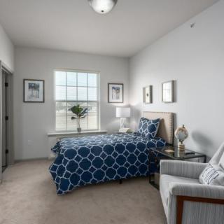 A modern bedroom with a patterned bedspread and elegant decor.