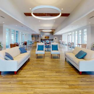 A spacious, modern lounge area with ample seating, featuring a minimalist design and abundant natural light.