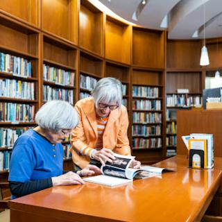 Two women enjoying a quiet moment together in a library, exploring books.