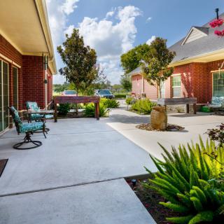 A well-maintained outdoor patio area with seating, surrounded by greenery and modern architecture.