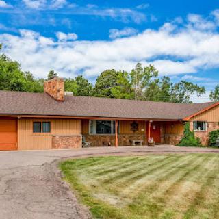 A charming single-story house with a well-maintained lawn and modern architectural features.