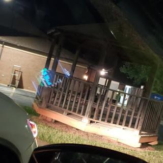 A nighttime view of a restaurant deck area, illuminated with soft lighting.