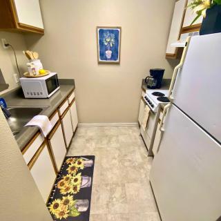 A small kitchen with appliances and sunflower-themed decor.